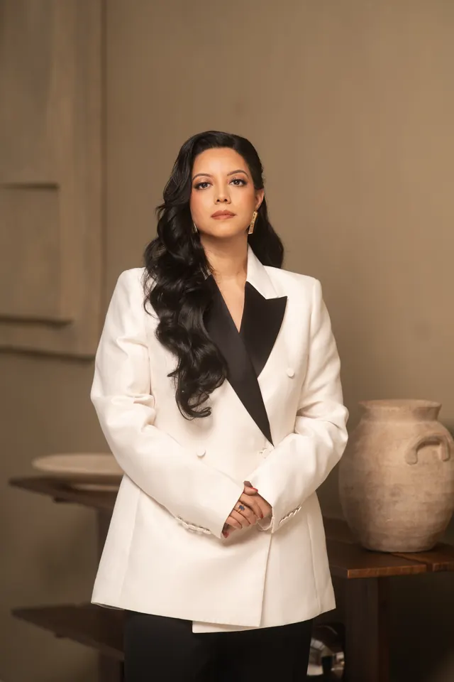 Priscilla Laclé standing in a white double-breasted suit